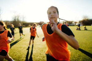Photo of a teenage girl, professional soccer player, having a game with her team mates